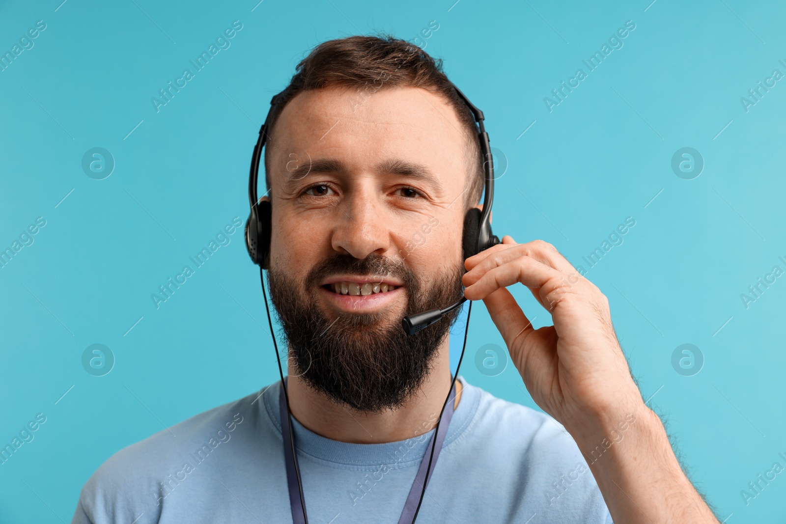 Photo of Technical support call center. Portrait of smiling operator on light blue background