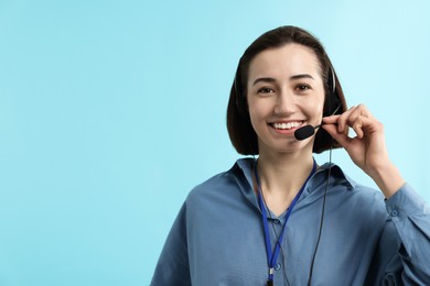 Photo of Technical support call center. Smiling operator on light blue background. Space for text