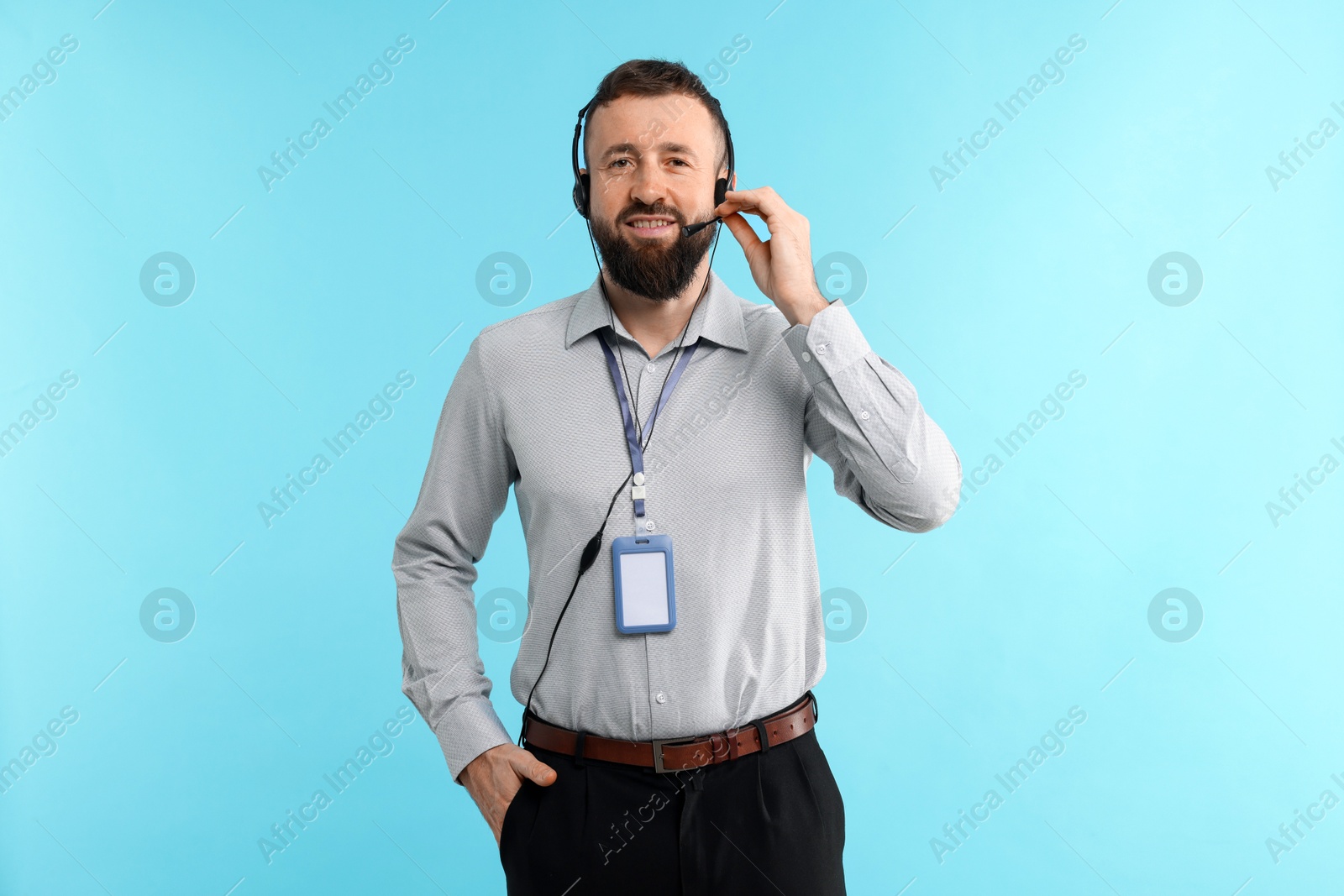 Photo of Technical support call center. Portrait of smiling operator on light blue background