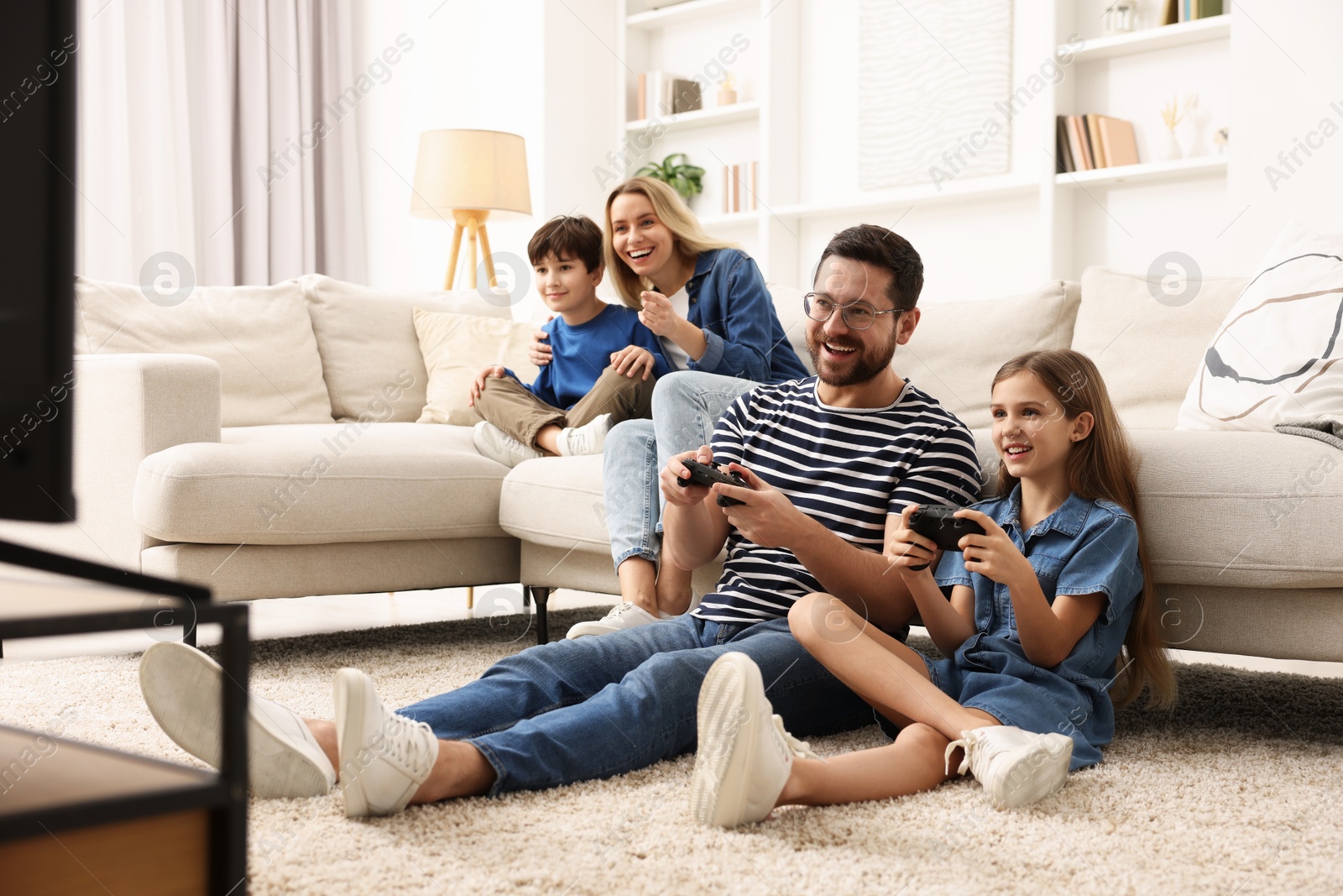 Photo of Happy family playing video games in living room