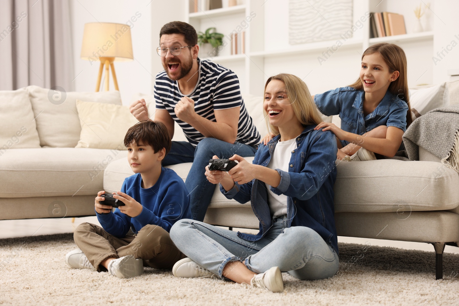 Photo of Happy family playing video games in living room