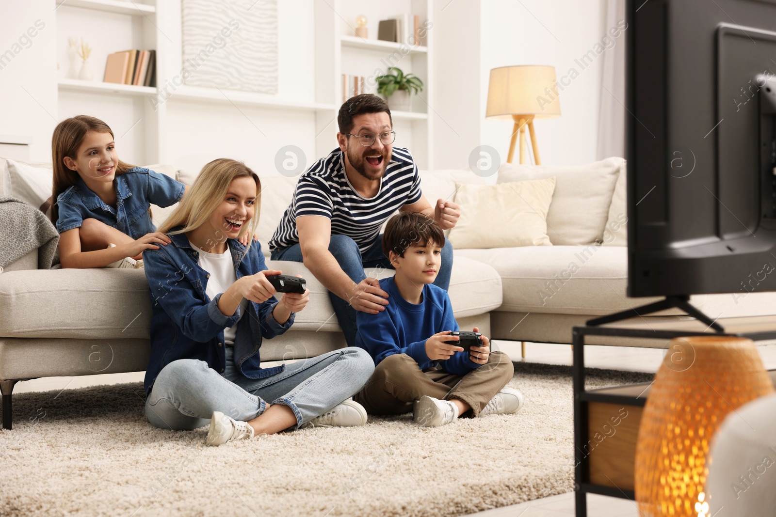 Photo of Happy family playing video games in living room