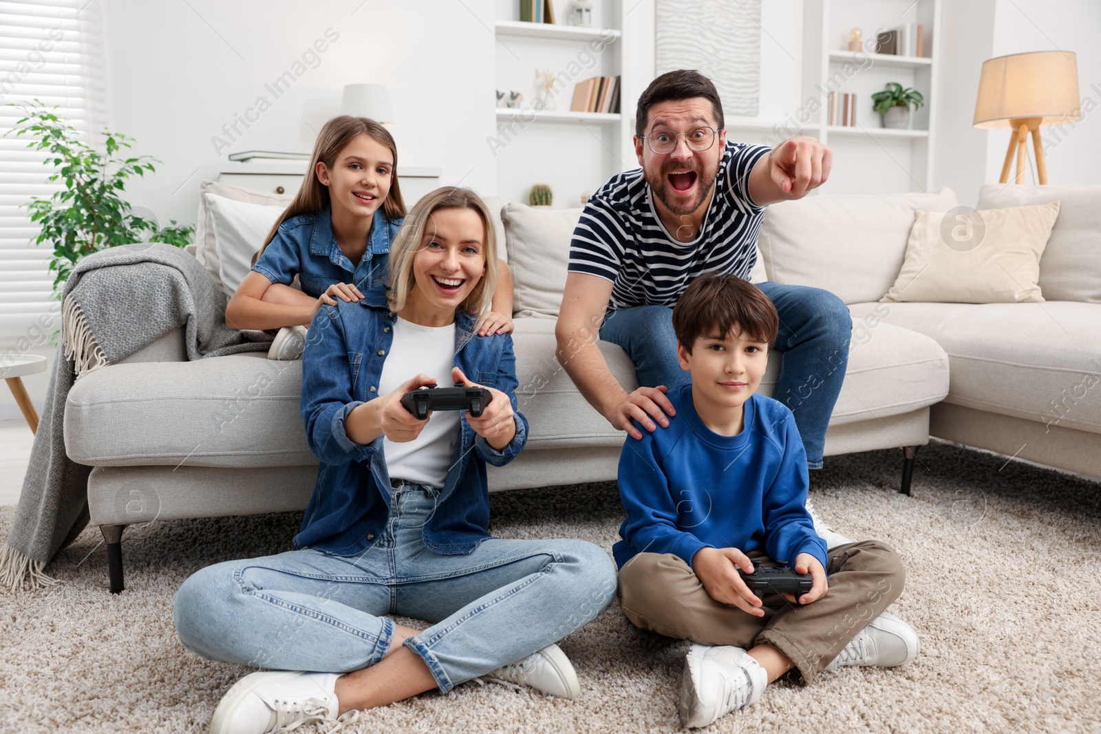 Photo of Happy family playing video games in living room