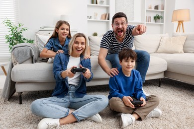 Photo of Happy family playing video games in living room