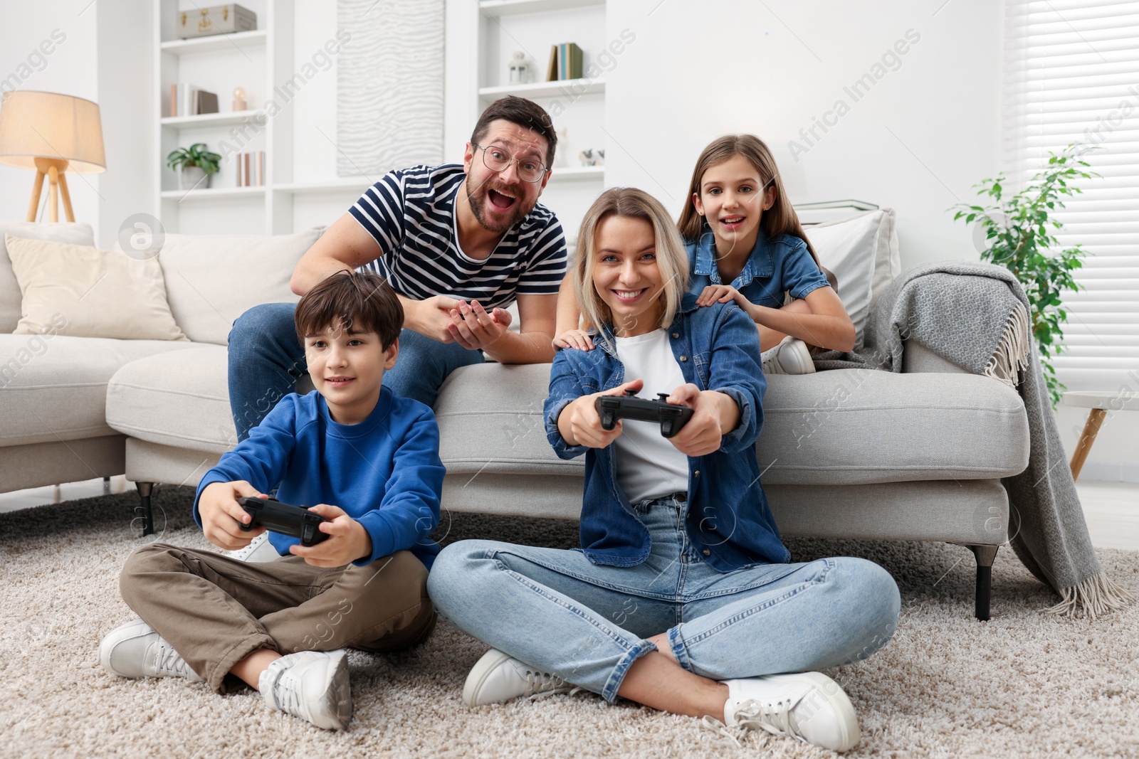 Photo of Happy family playing video games in living room