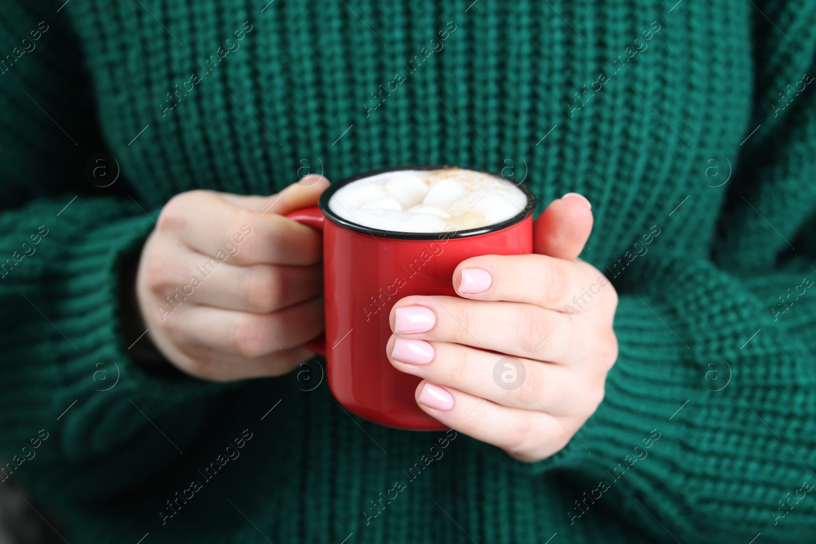 Photo of Woman holding mug of tasty hot chocolate with marshmallows, closeup