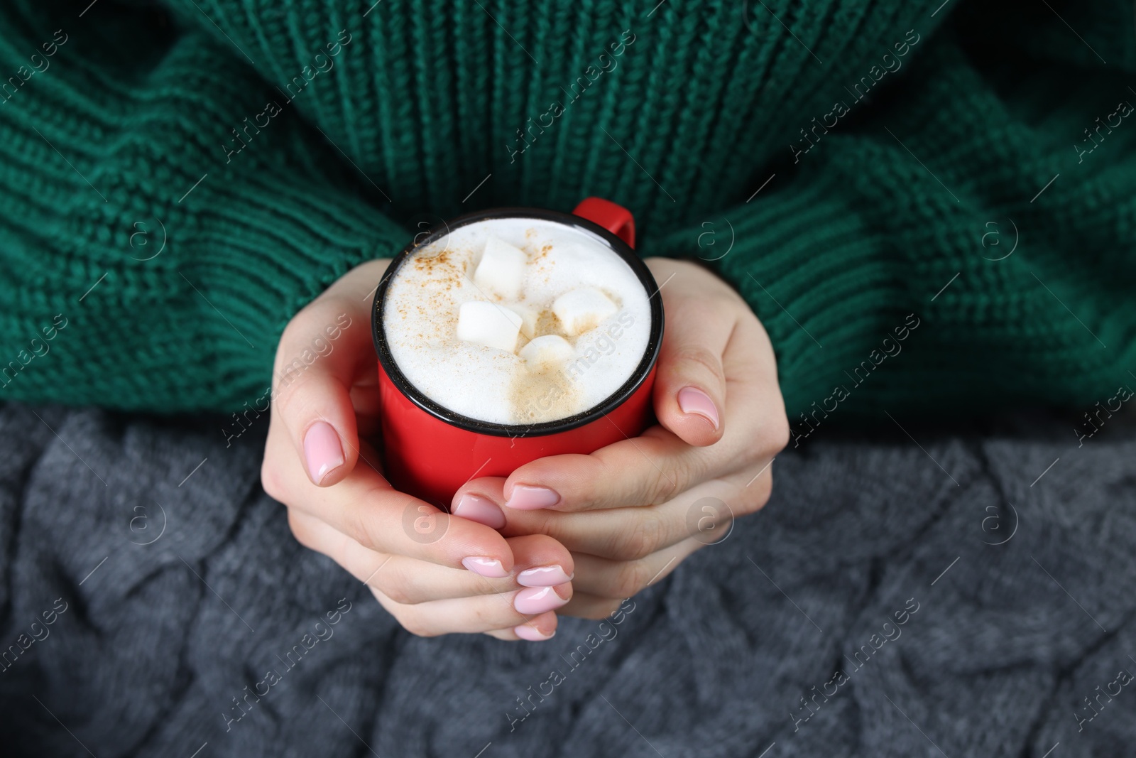 Photo of Woman holding mug of tasty hot chocolate with marshmallows, closeup