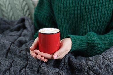 Photo of Woman holding mug of tasty hot chocolate with marshmallows, closeup