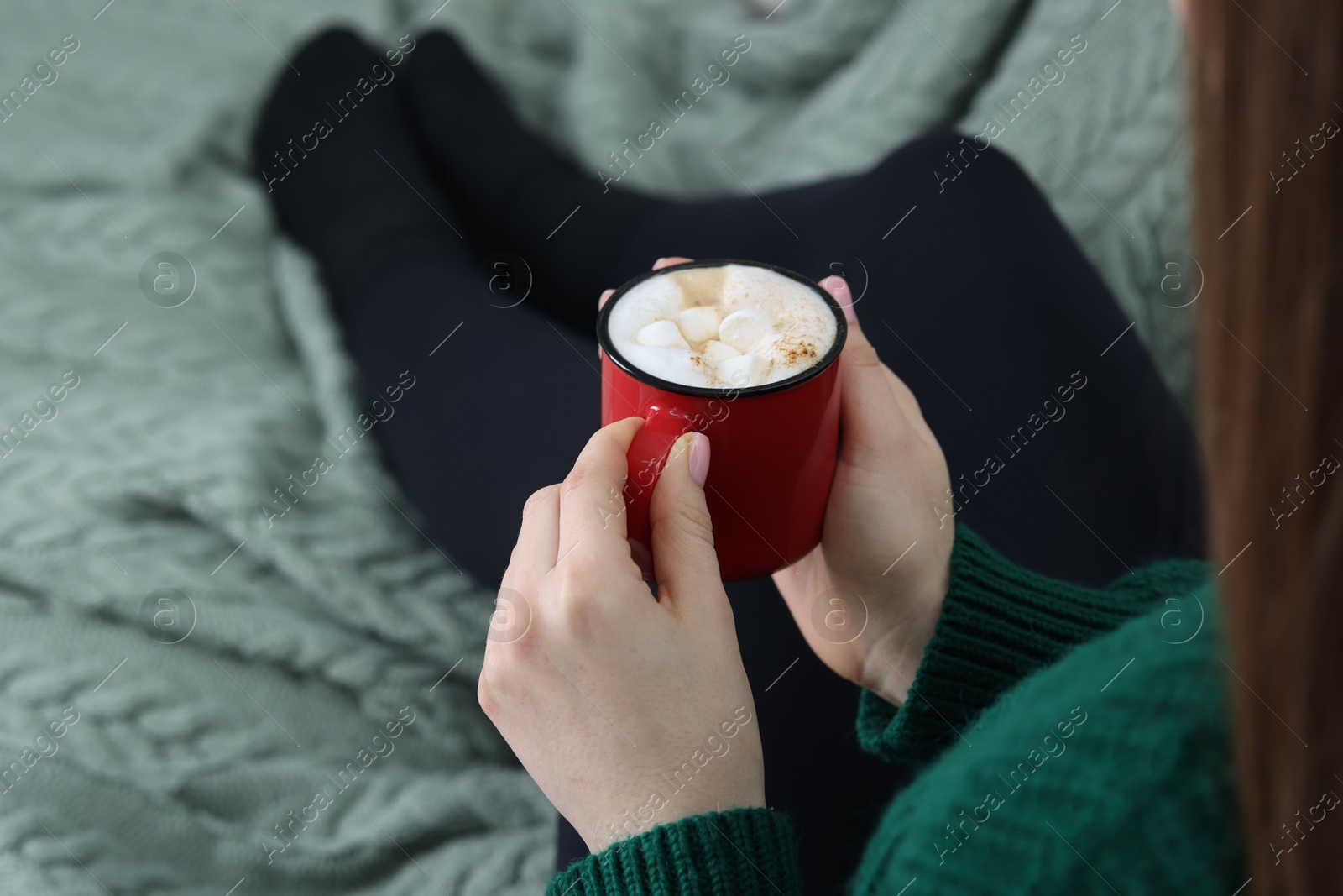 Photo of Woman holding mug of tasty hot chocolate with marshmallows, closeup