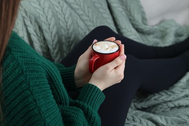 Photo of Woman holding mug of tasty hot chocolate with marshmallows, closeup