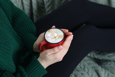 Photo of Woman holding mug of tasty hot chocolate with marshmallows, closeup