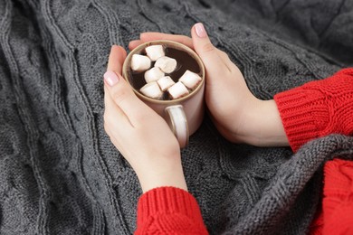 Photo of Woman holding mug of tasty hot chocolate with marshmallows, closeup