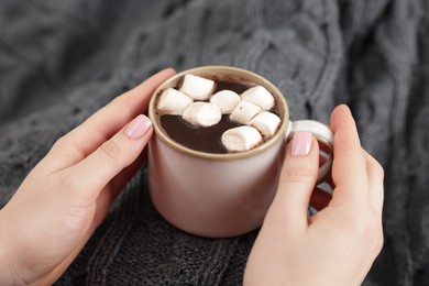 Photo of Woman holding mug of tasty hot chocolate with marshmallows, closeup