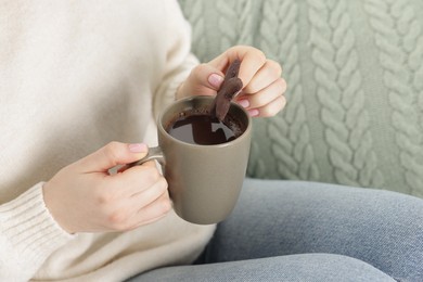 Photo of Woman having tasty hot chocolate with cookie, closeup