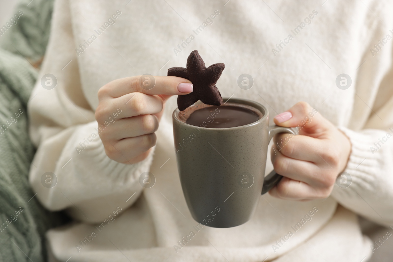 Photo of Woman having tasty hot chocolate with cookie, closeup