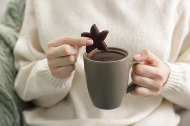 Photo of Woman having tasty hot chocolate with cookie, closeup