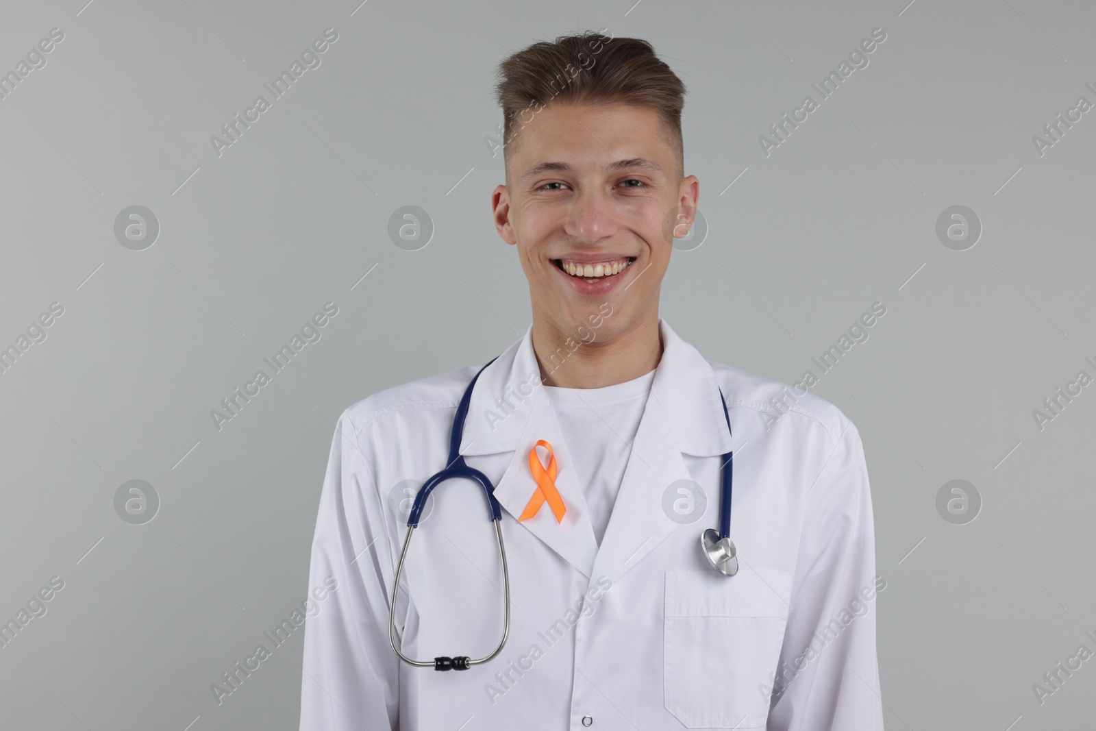 Photo of Multiple Sclerosis awareness. Doctor with orange ribbon on light grey background