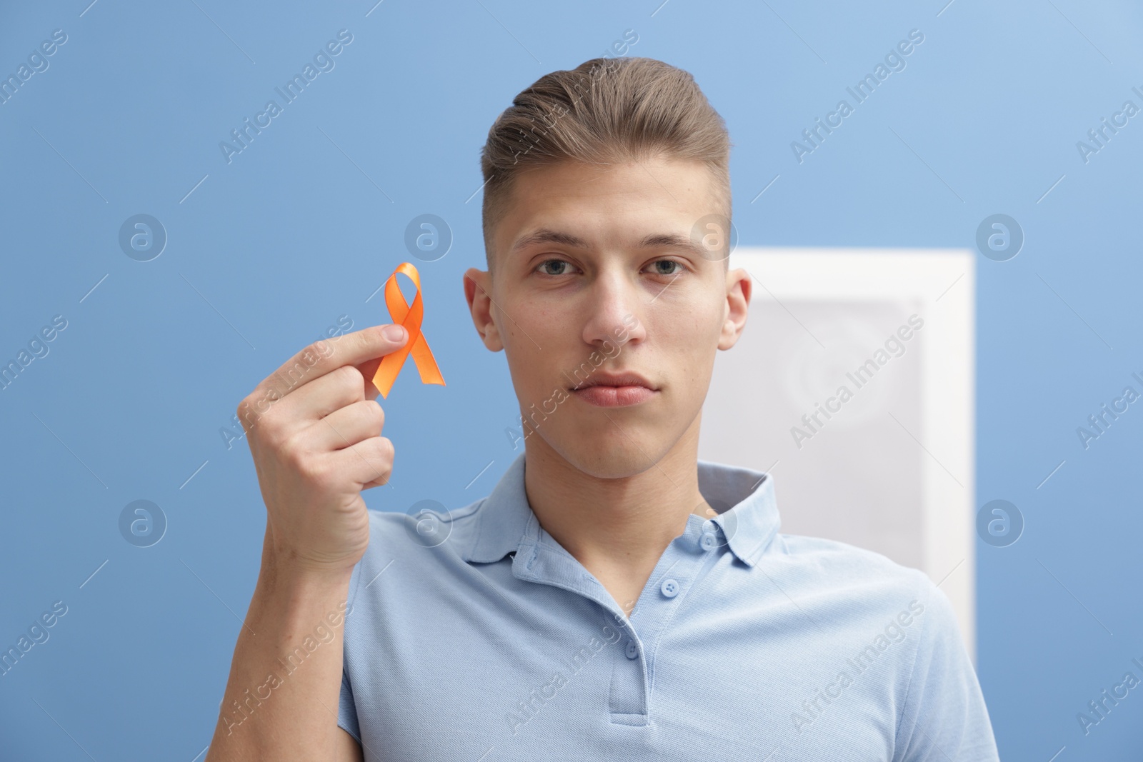 Photo of Multiple Sclerosis awareness. Man with orange ribbon indoors