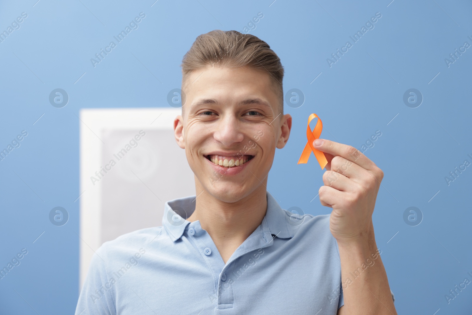 Photo of Multiple Sclerosis awareness. Man with orange ribbon indoors