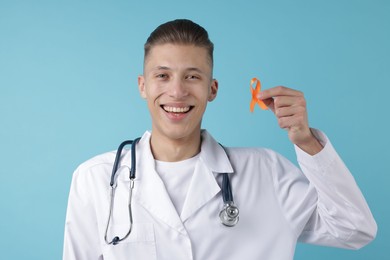 Photo of Multiple Sclerosis awareness. Doctor with orange ribbon on light blue background