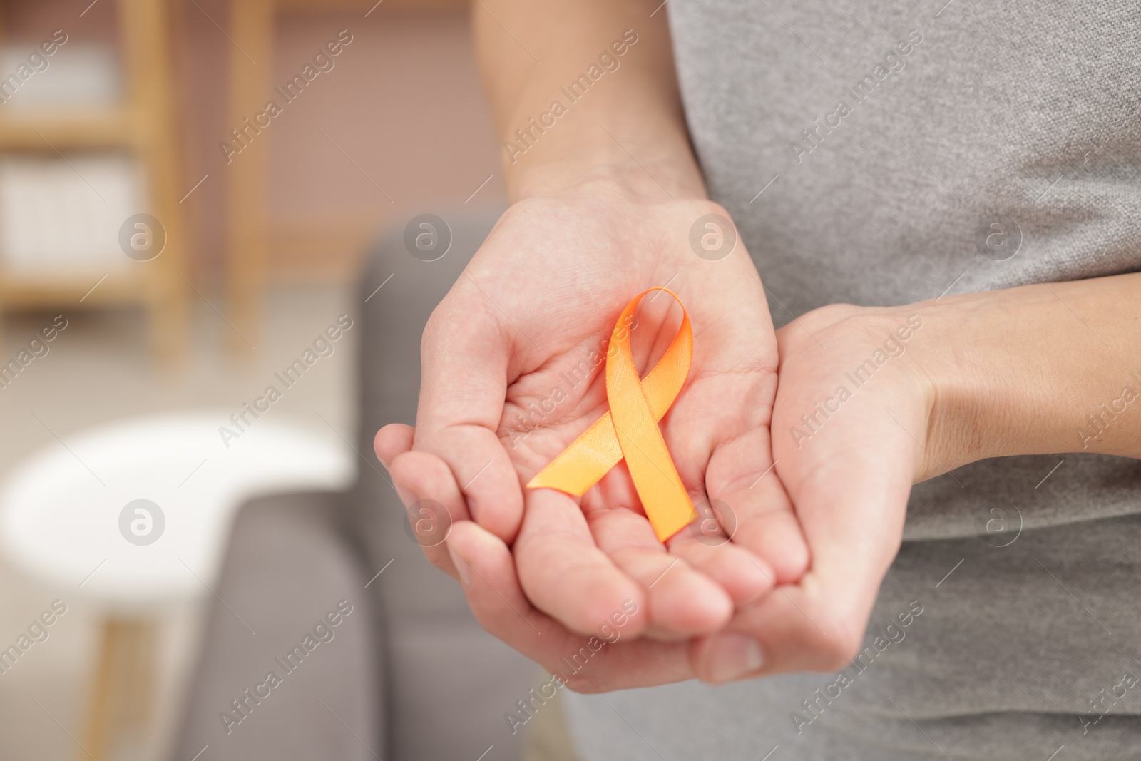 Photo of Multiple Sclerosis awareness. Man with orange ribbon indoors, closeup