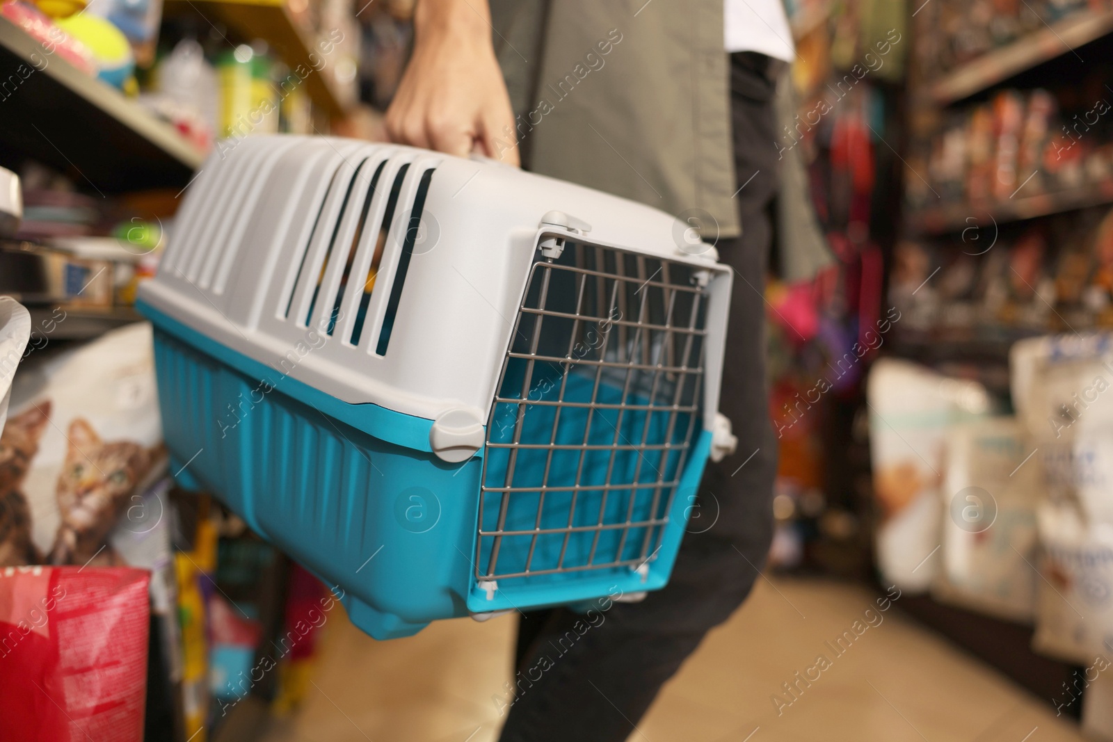 Photo of Woman with carrier in pet shop, closeup