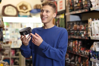 Photo of Happy man with feeding bowl in pet shop