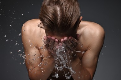 Photo of Man washing his face on black background