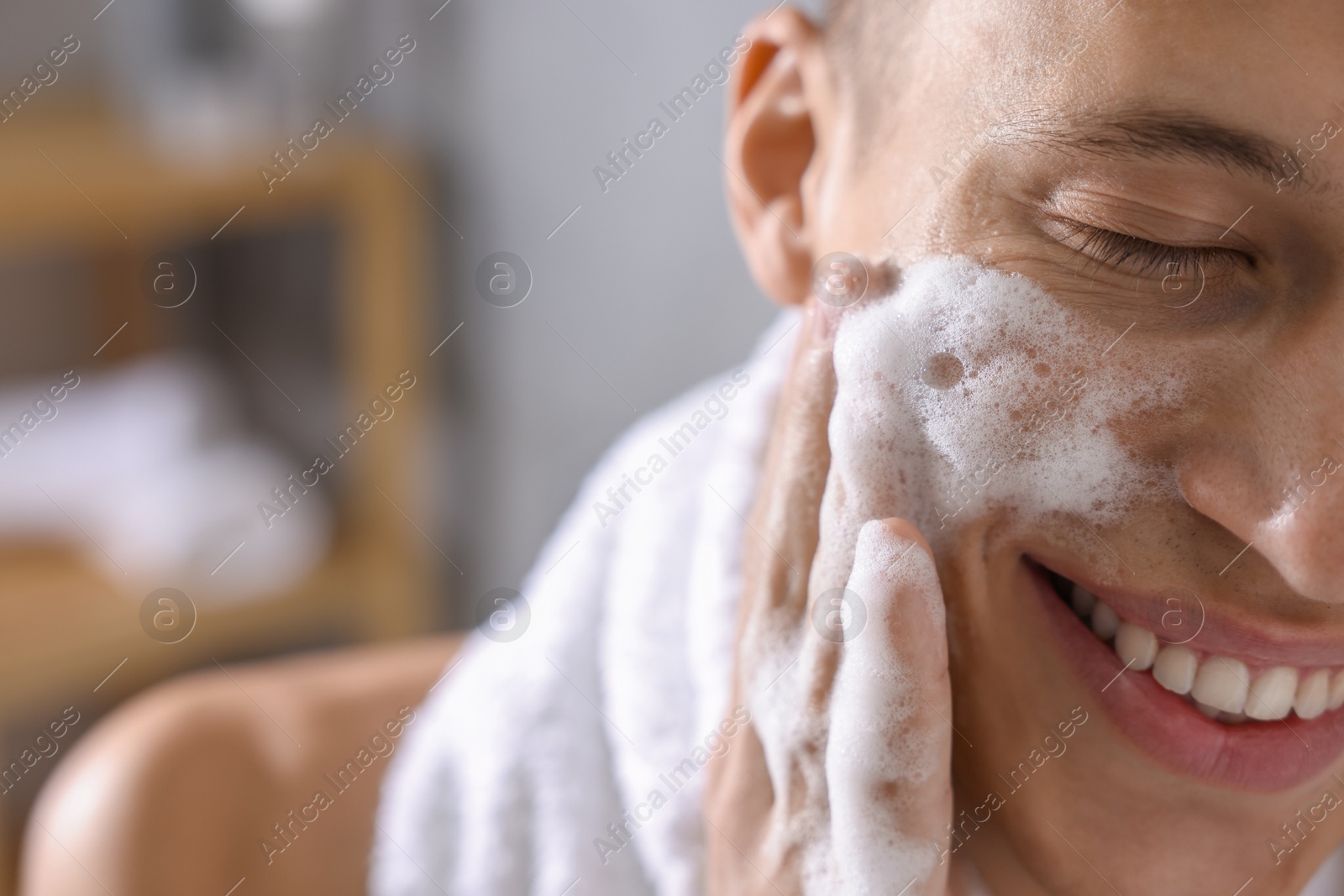 Photo of Man washing his face with cosmetic product in bathroom, closeup. Space for text