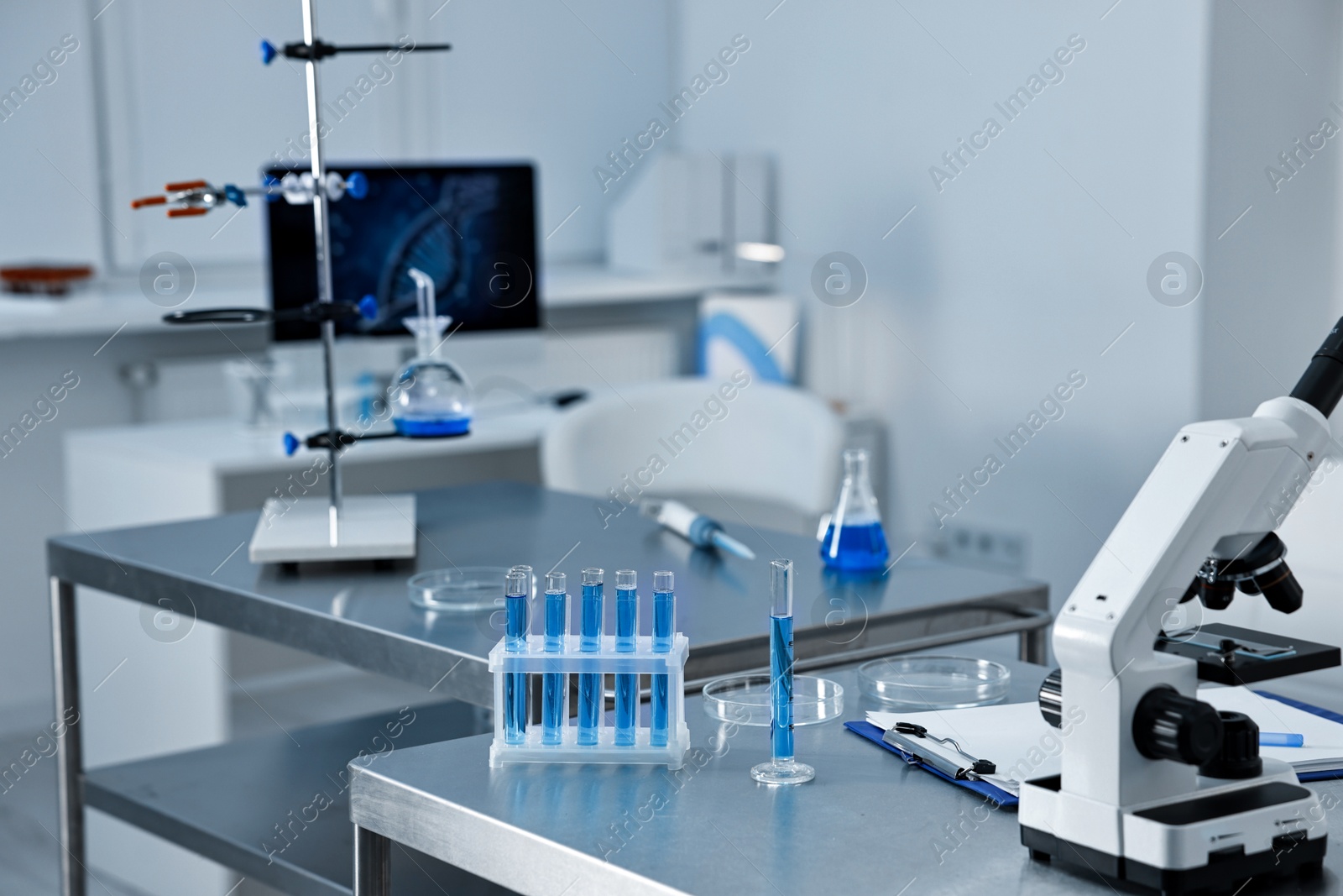 Photo of Chemical glassware and microscope on table in laboratory