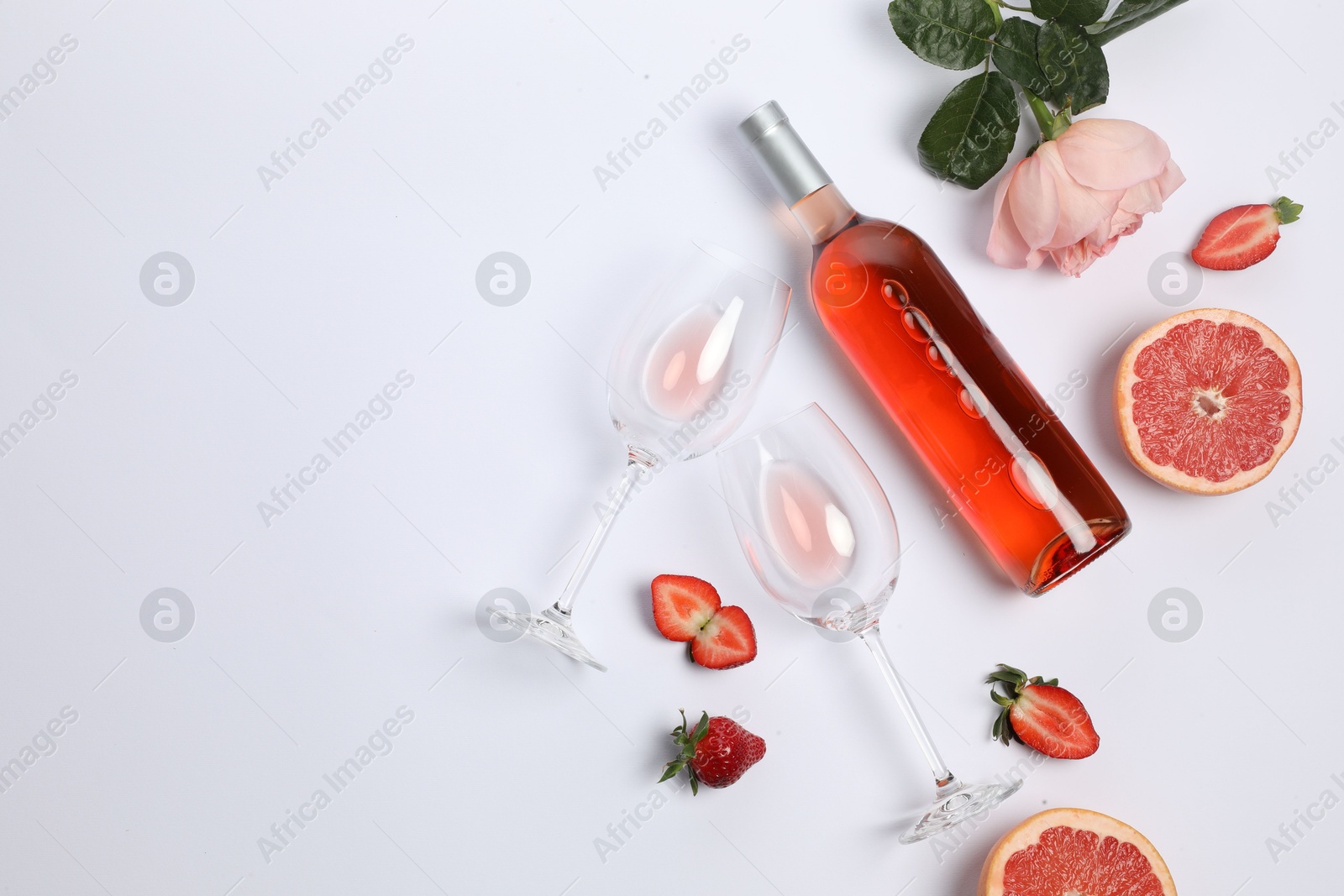 Photo of Flat lay composition with rose wine and fruits on white background. Space for text