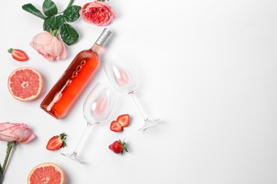 Flat lay composition with rose wine and fruits on white background. Space for text