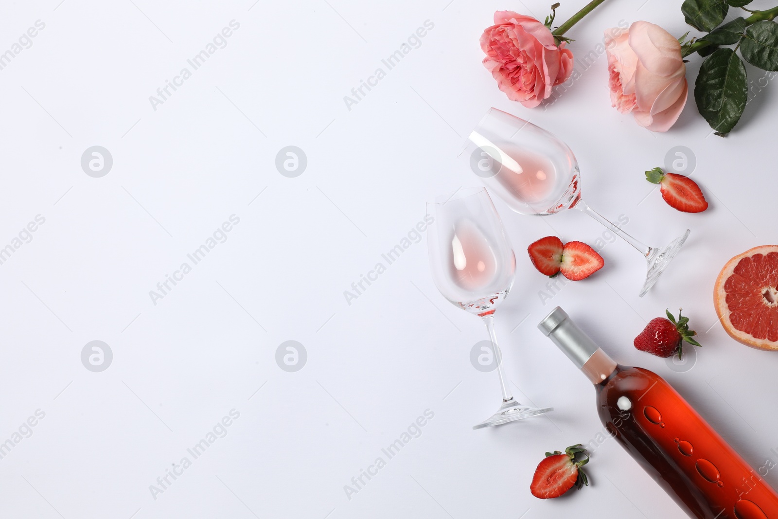 Photo of Flat lay composition with rose wine and fruits on white background. Space for text