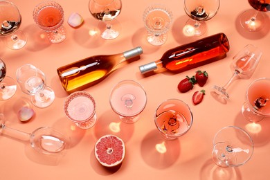 Flat lay composition with delicious rose wine on coral color background