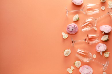 Flat lay composition with wineglasses and beautiful flowers on coral color background. Space for text