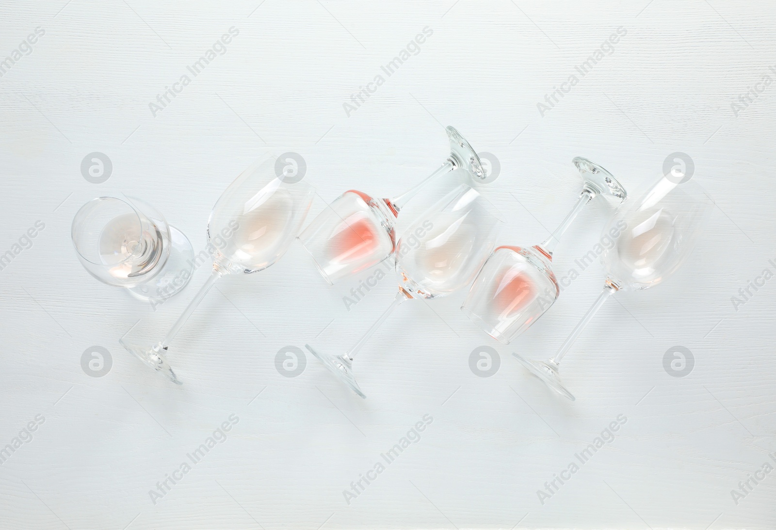 Photo of Wineglasses on white wooden table, flat lay