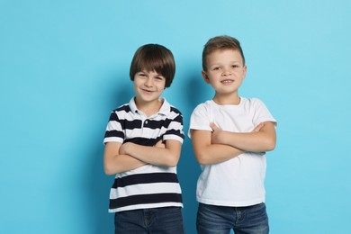 Photo of Portrait of cute brothers on light blue background