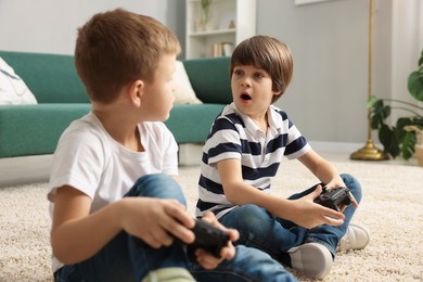 Photo of Cute brothers playing video game on floor at home