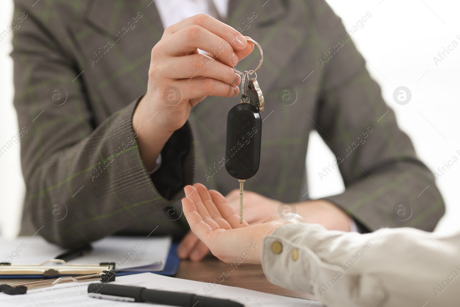 Photo of Buying auto. Client getting car key at table, closeup