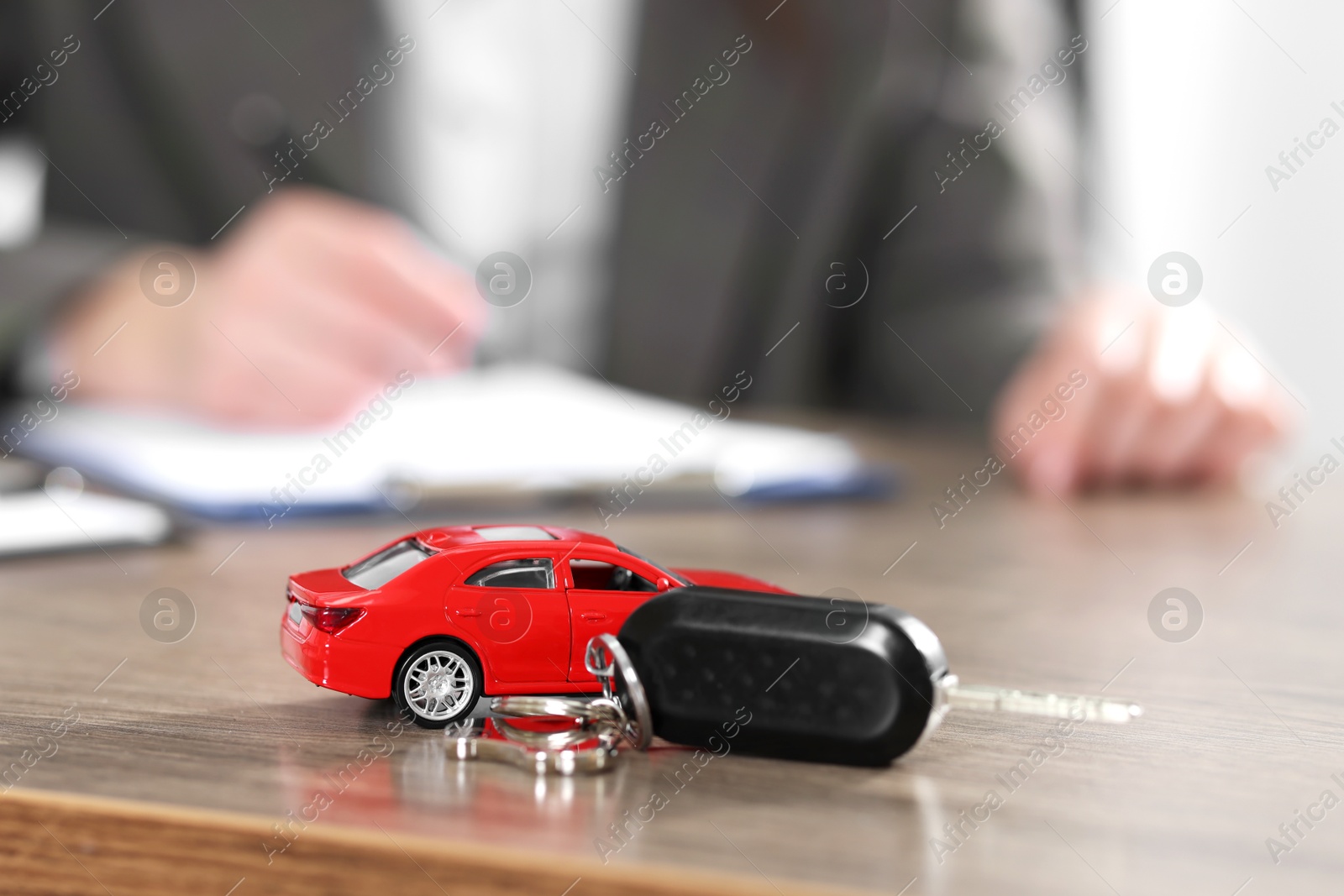 Photo of Client signing car purchase agreement at wooden table, selective focus. Buying auto