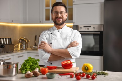 Photo of Professional chef with fresh products at table in kitchen