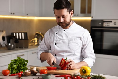 Photo of Professional chef cutting bell pepper at table in kitchen