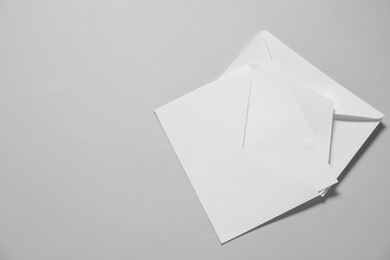 Photo of Paper envelopes with letter on gray background, top view. Mockup for design