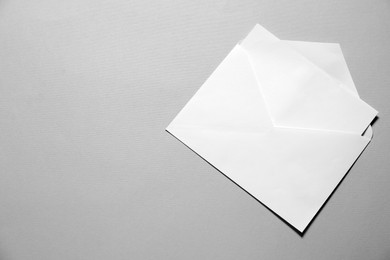 Photo of Paper envelope with letter on gray background, top view. Mockup for design