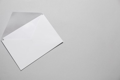 Photo of Paper envelope with letter on gray background, top view. Mockup for design