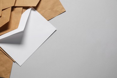 Photo of Paper envelopes on gray background, flat lay. Mockup for design