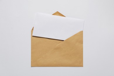 Kraft paper envelope with letter on white background, top view. Mockup for design