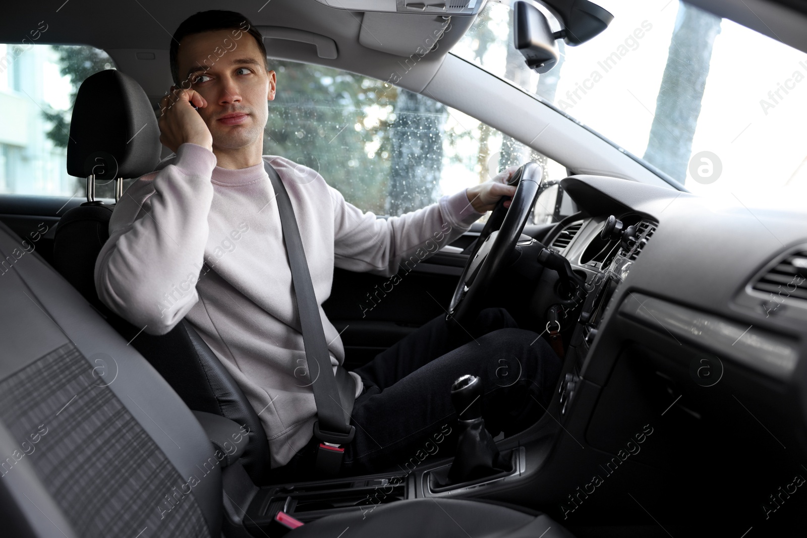 Photo of Driver talking on smartphone while driving modern car