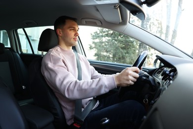 Photo of Driver behind steering wheel of modern car