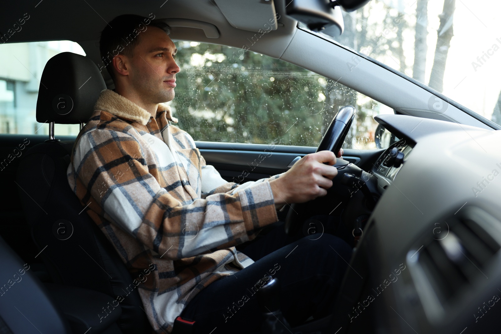 Photo of Driver behind steering wheel of modern car